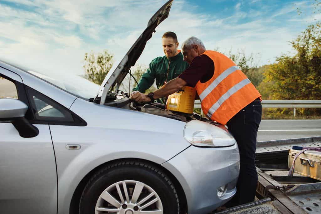 Two workers jump starting car